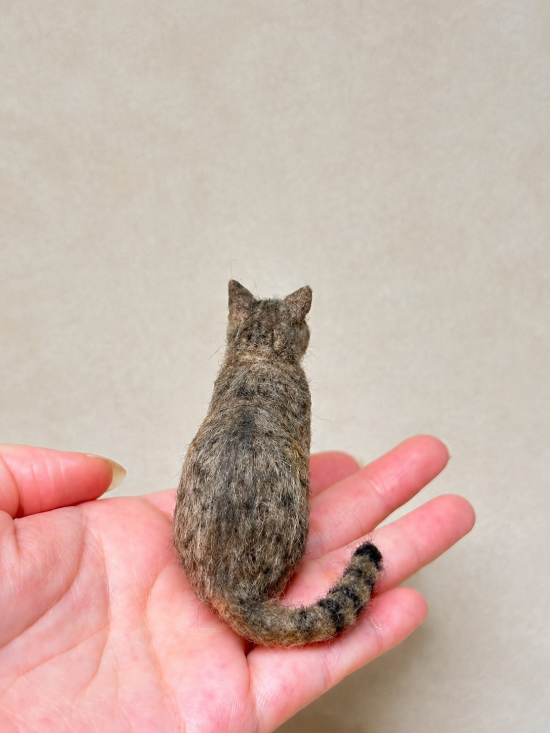Back view of a handcrafted miniature wool tabby cat figurine