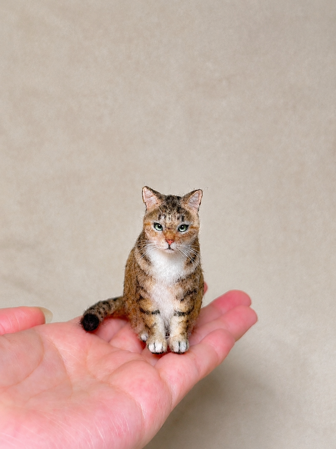 Front view of a handcrafted miniature wool tabby cat figurine